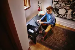 uomo seduto alla scrivania che scrive al computer