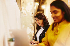 due donne che lavorano al pc. grafica Randstad Workmonitor 2023