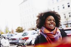 una donna sorridente i primo piano in un contesto urbano