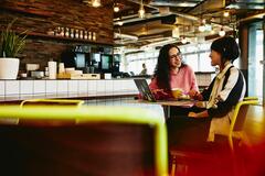 due donne che parlano sedute ad un tavolo in un bar