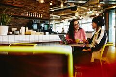 due donne che parlano sedute ad un tavolo in un bar