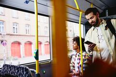 un ragazzo in piedi su un autobus che controlla il telefono - schema turni di lavoro