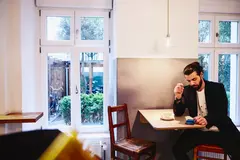 persona seduta al bar che guarda il telefono