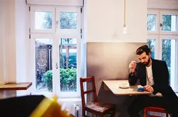persona seduta al bar che guarda il telefono