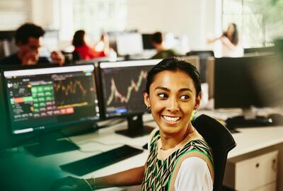 una ragazza sorridente che lavora al pc elaborando grafici