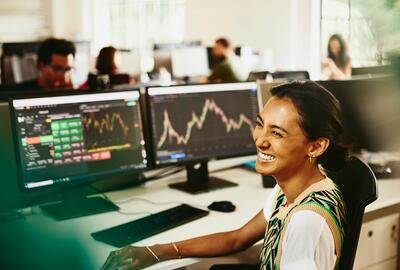 una donna sorridente davanti ad un pc con grafici - People Analytics