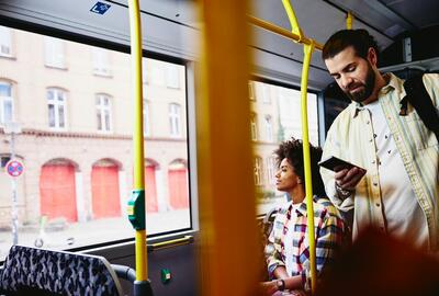 un ragazzo in piedi su un autobus che controlla il telefono - schema turni di lavoro
