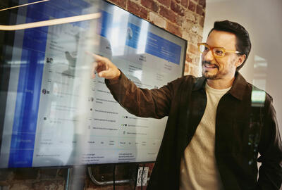 uomo indica delle dashboard hr su un monitor