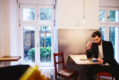 persona seduta al bar che guarda il telefono