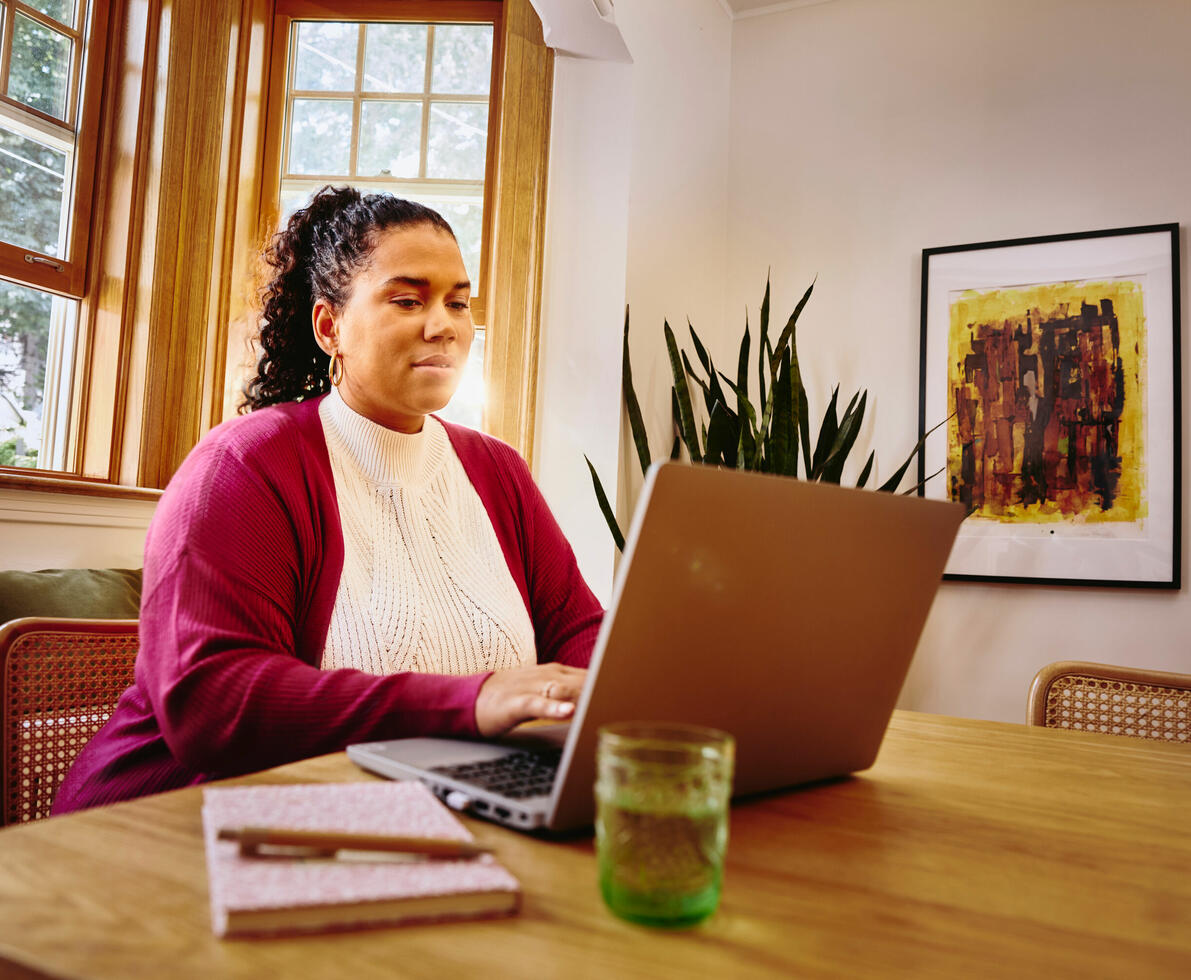 una donna che lavora al pc nella sala di casa