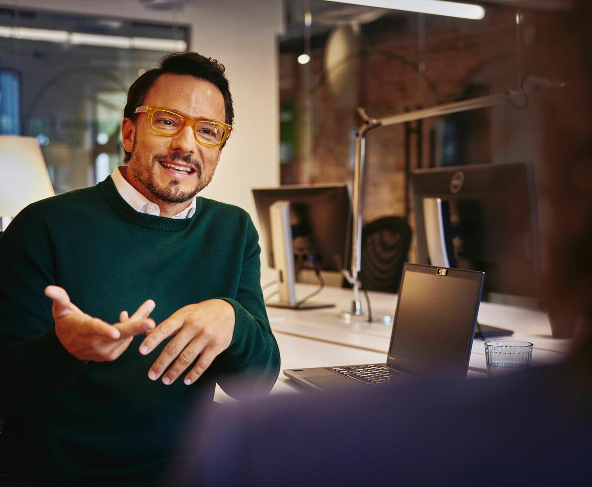 un uomo che parla ad un collega di spalle