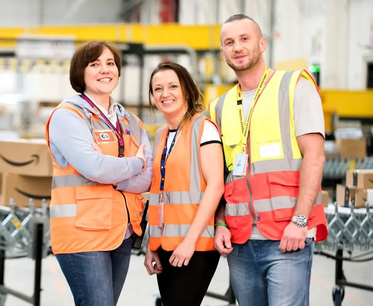 amazon-warehouse-workers-stood-smiling-to-camera-in-warehouse