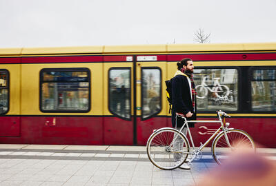 un ragazzo alla banchina del treno che sorregge una bicicletta
