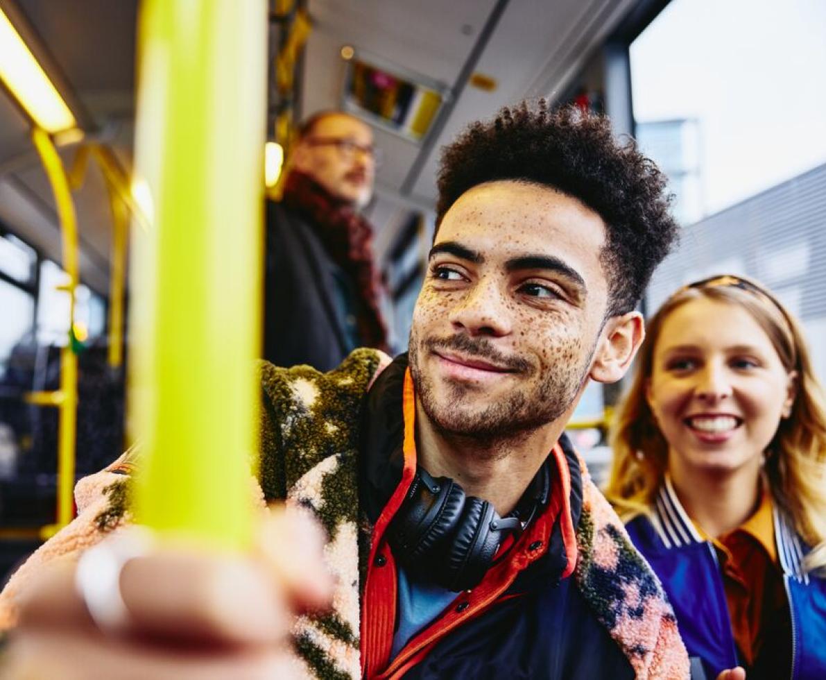 Woman and boy smiling, sitting in a bus