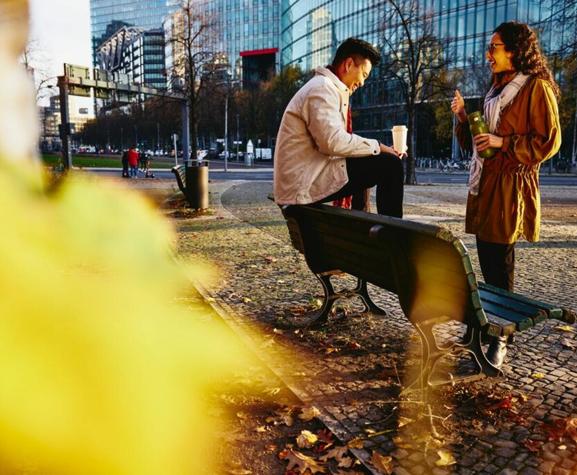 un ragazzo seduto su una panchina e una ragazza al parco che parlano
